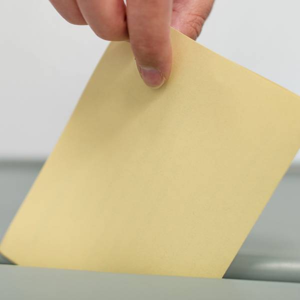 Ein Stimmzettel wird in eine Wahlurne geworfen. (Symbolbild)