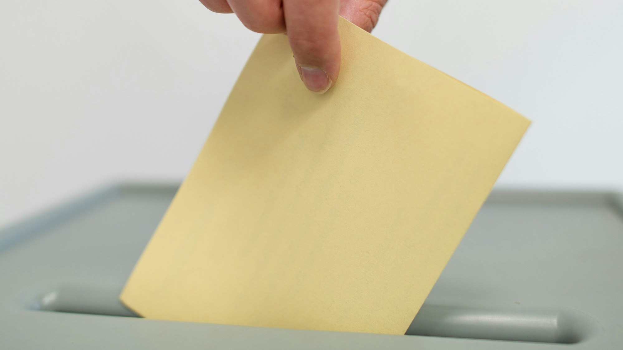 Ein Stimmzettel wird in eine Wahlurne geworfen. (Symbolbild)