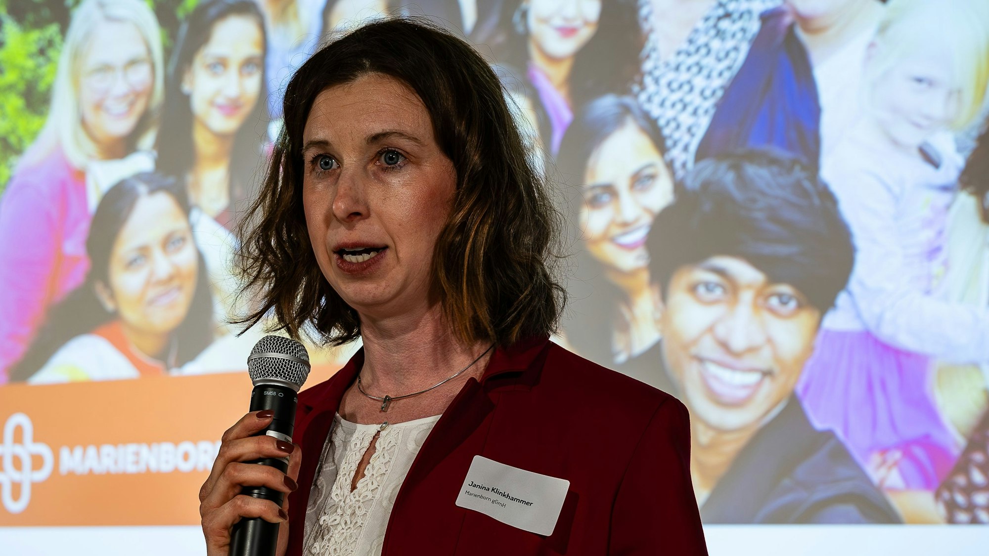 Janina Klinhammer bei ihrem Pitch, im Hintergrund ein Foto der internationalen Ausbildungsschar von Marienborn.