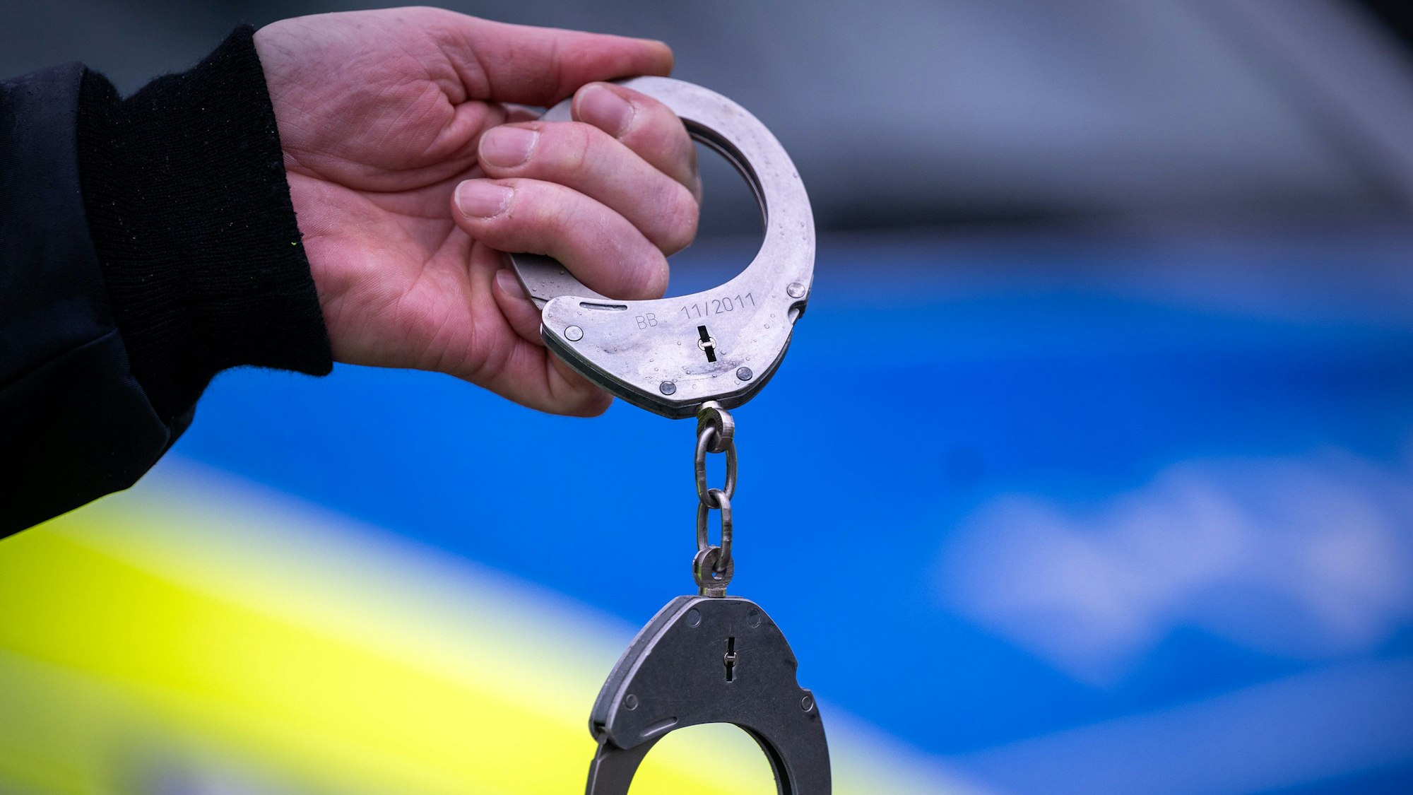 Ein Polizist hält während einer Verkehrskontrolle ein Paar Handschellen.