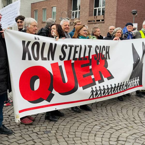 Rund 20 Menschen halten auf dem Alter Markt ein Banner mit dem Schriftzug „Köln stellt sich quer“
