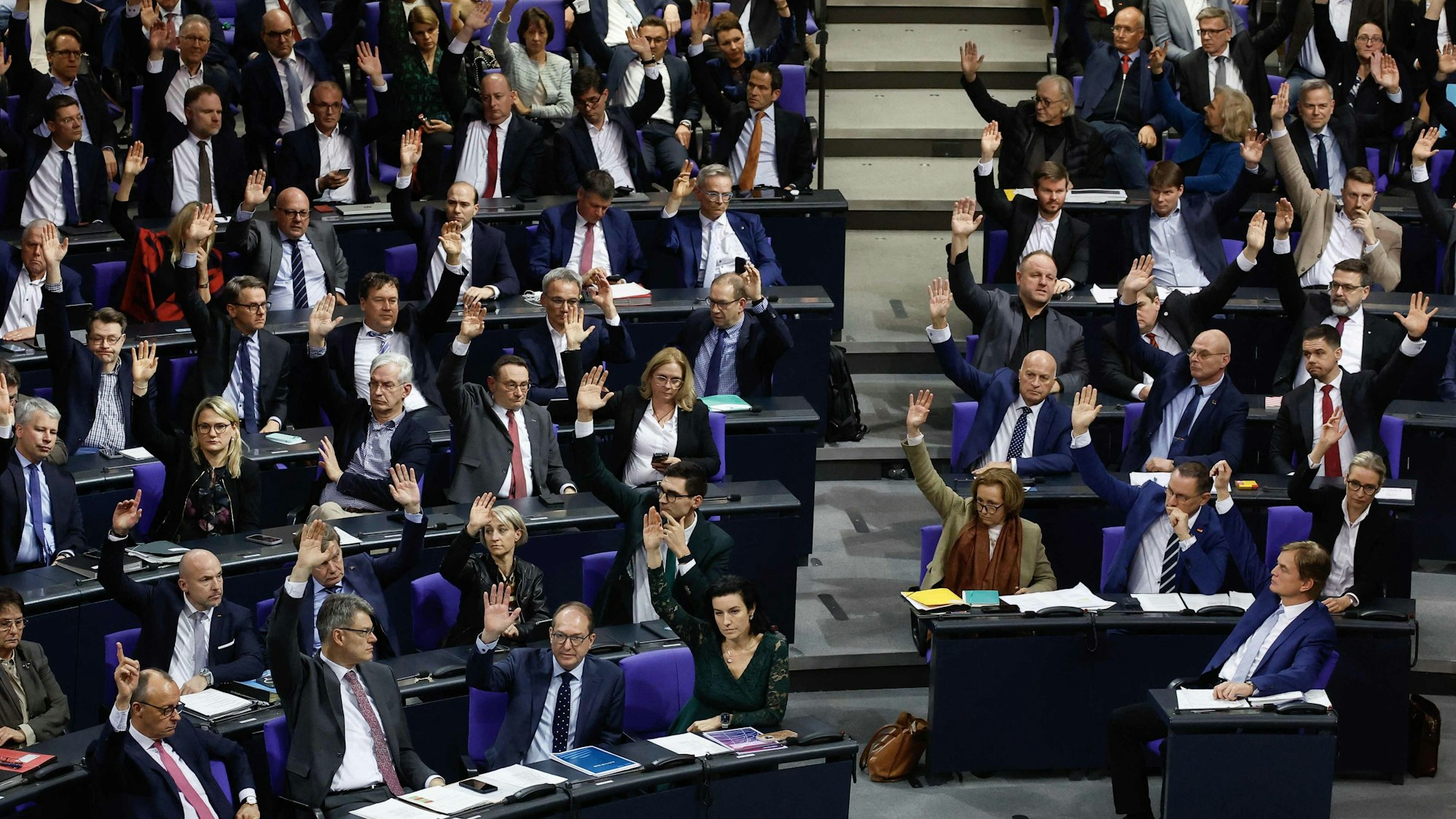 AfD und CDU/CSU heben zusammen die Hand im Deutschen Bundestag.