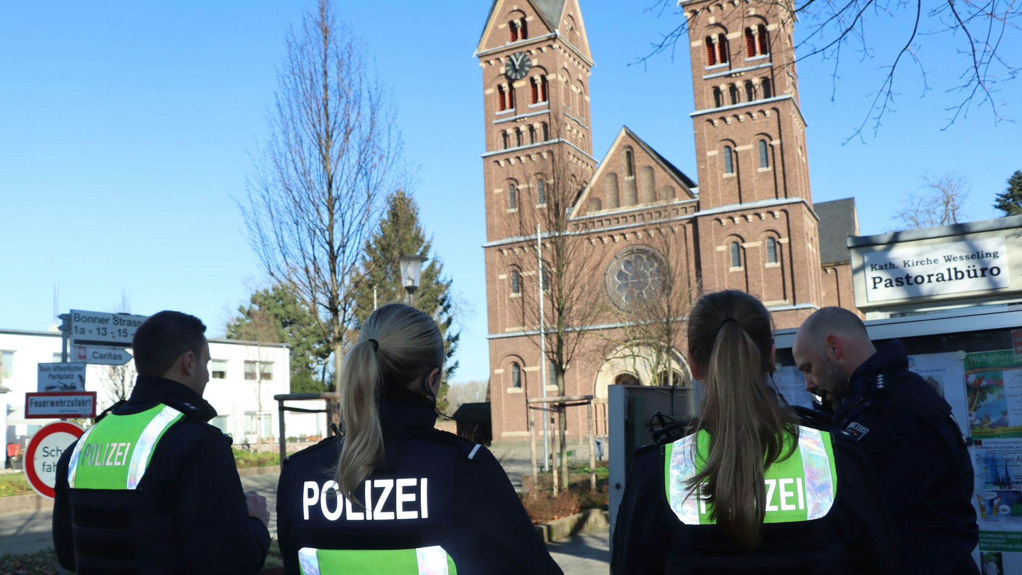 Polizeibeamte stehen vor einer Kirche.