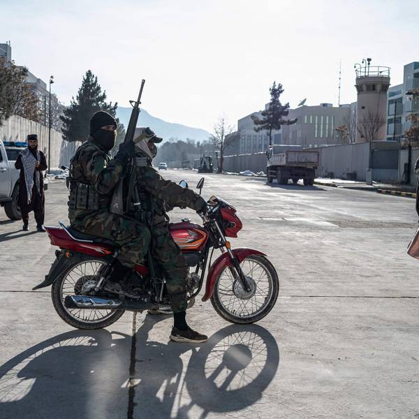 Taliban security personnel ride past the former US Embassy building in Kabul