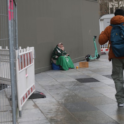 Ein Passant geht an einer Bettlerin vorüber.