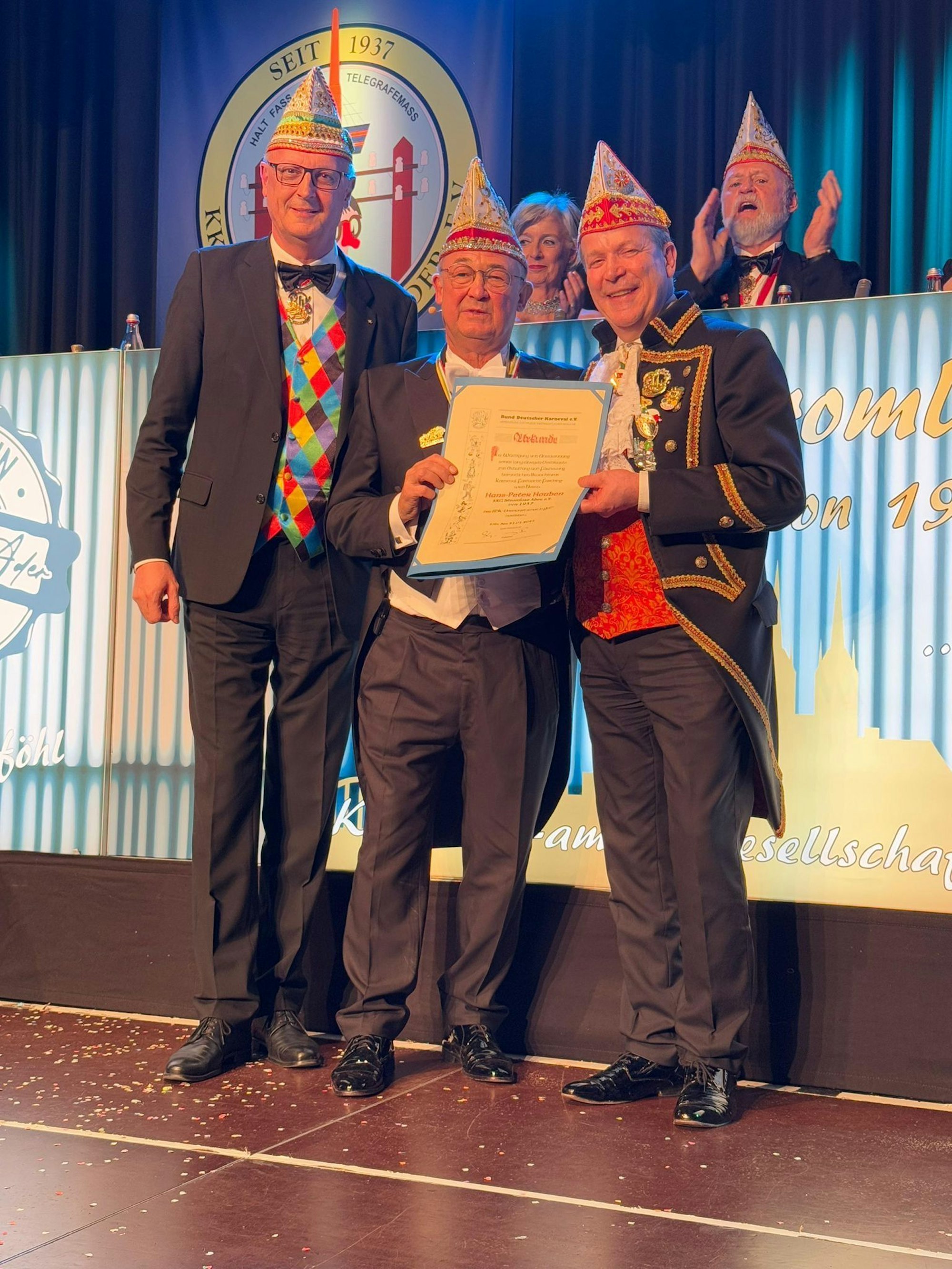BDK-Präsident Klaus-Ludwig Fess (l.) und FK-Präsident Christoph Kuckelkorn (r.) ehren den Präsidenten der KKG Stromlose Ader, Hans-Peter Houben mit dem Verdienstorden in Gold des BDK.