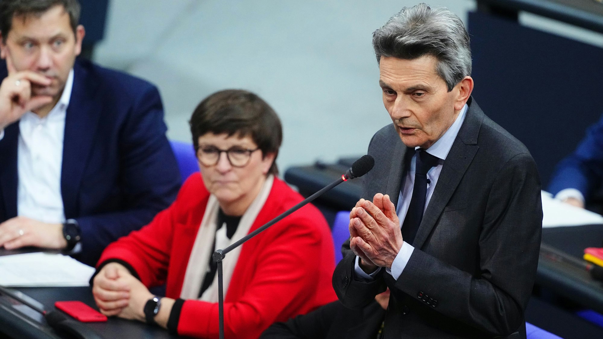 Rolf Mützenich, Vorsitzender der SPD-Bundestagsfraktion, spricht während der Debatte zur Migration im Plenarsaal im Bundestag. Im Hintergrund sind die SPD-Vorsitzenden Lars Klingbeil und Saskia Esken zu sehen.