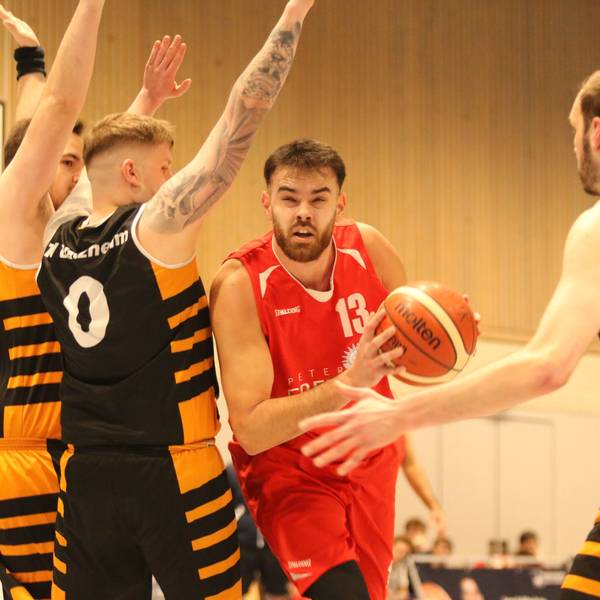 Erftbaskets-Spieler Marko Vojinovic hat den Ball in der Hand, drei Spieler stellen sich ihm entgegen.