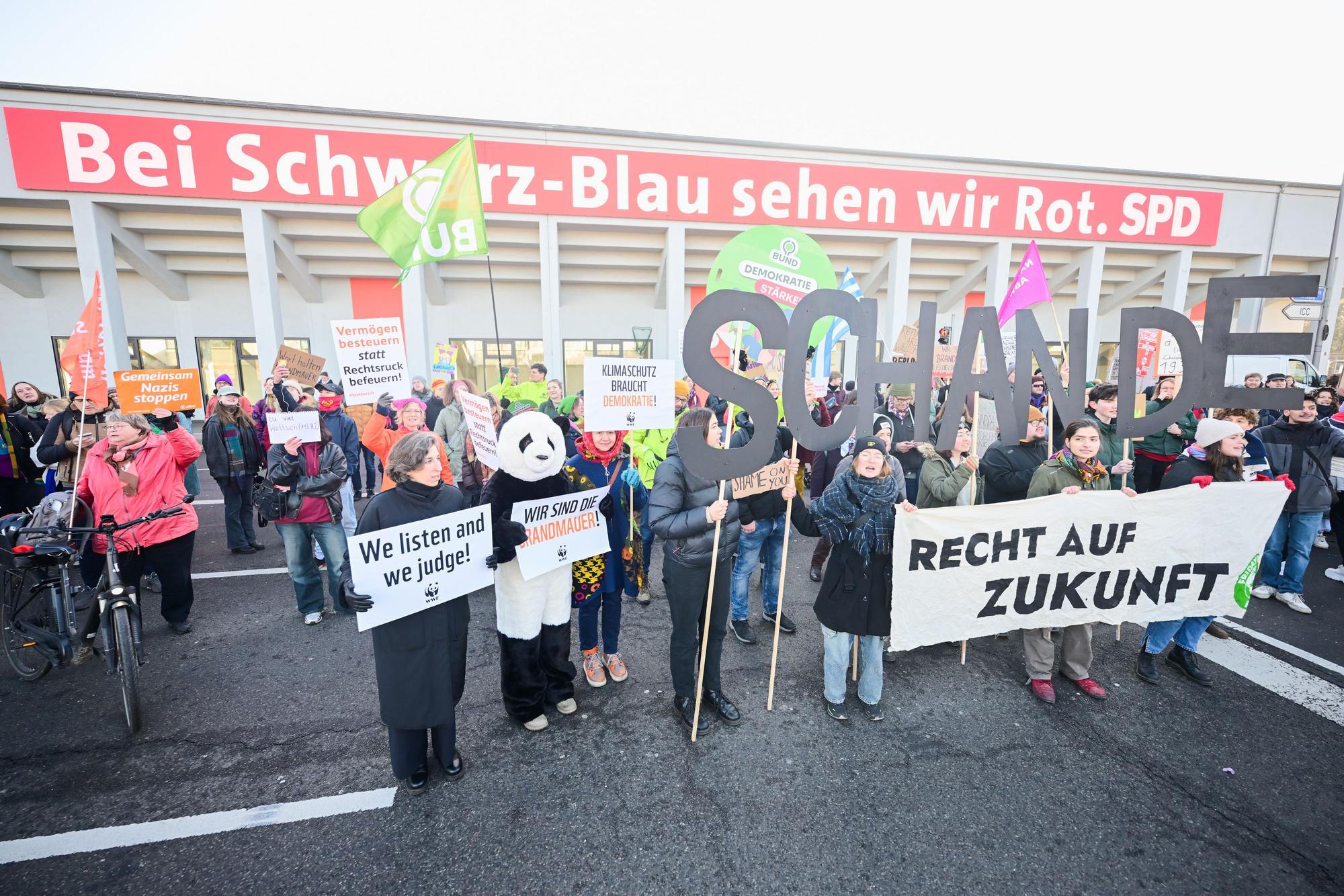 03.02.2025, Berlin: Demonstranten mit Plakaten und Schildern, die das Wort "Schande" bilden, stehen vor Beginn des 37. Bundesparteitag der CDU im CityCube Berlin vor dem Veranstaltungsgelände. Foto: Sebastian Christoph Gollnow/dpa +++ dpa-Bildfunk +++