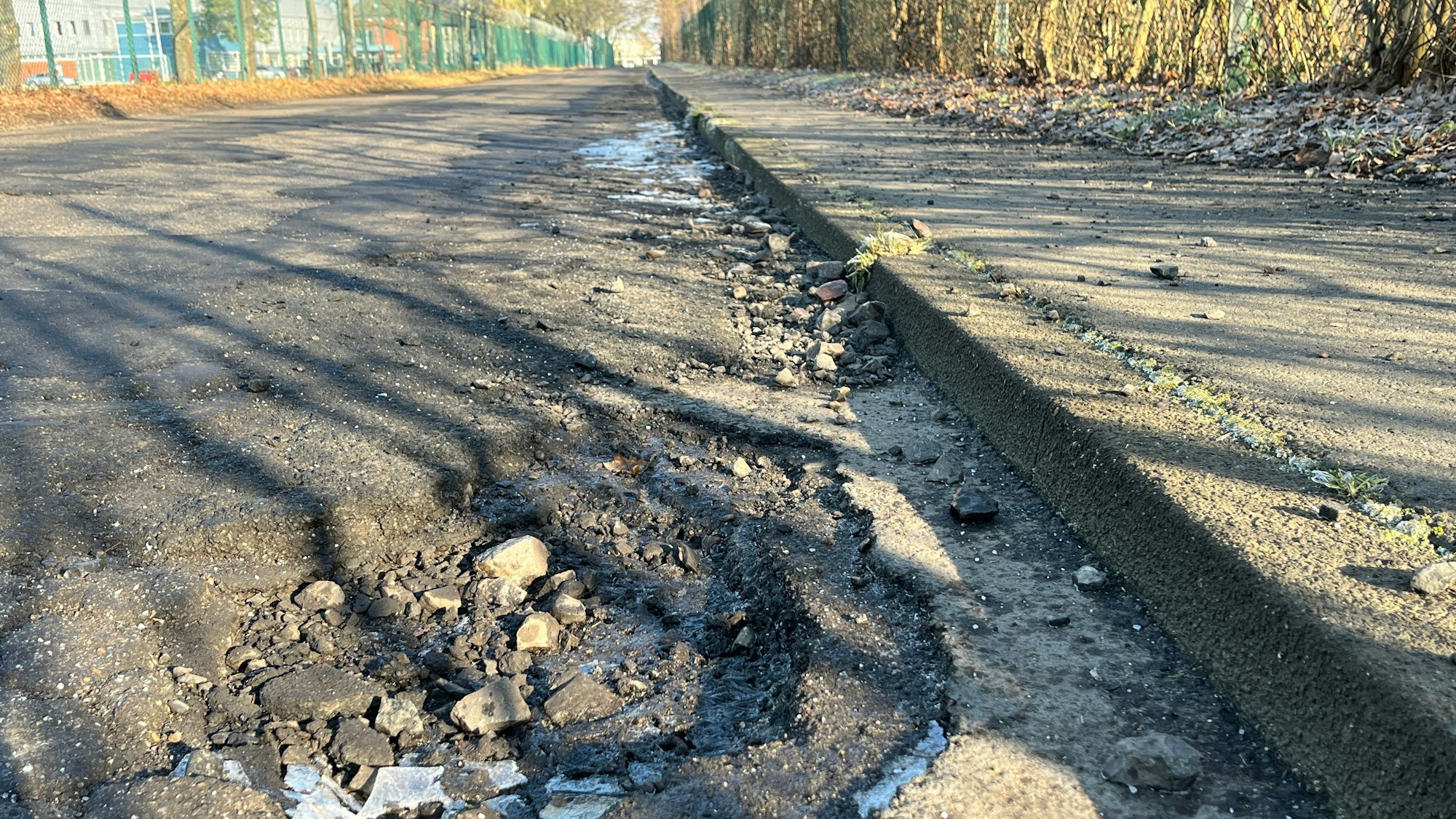 Eine Straße mit tiefen Schlaglöchern.