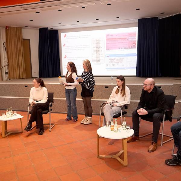 Die Gesprächsteilnehmer sitzen an Tischen. Marja Hölz und Clara Gehlen moderierten die Veranstaltung stehend.
