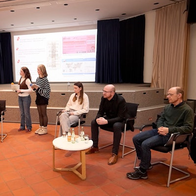 Die Gesprächsteilnehmer sitzen an Tischen. Marja Hölz und Clara Gehlen moderierten die Veranstaltung stehend.