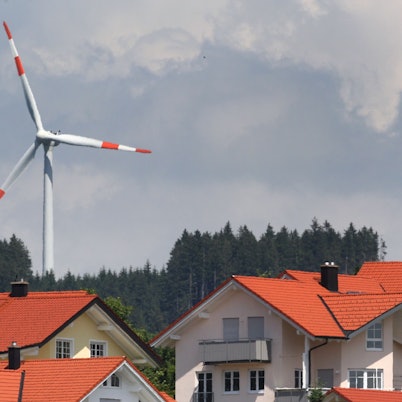 Ein Windrad steht am 21.06.2012 hinter einer Neubausiedlung in Wildpoldsried (Bayern).