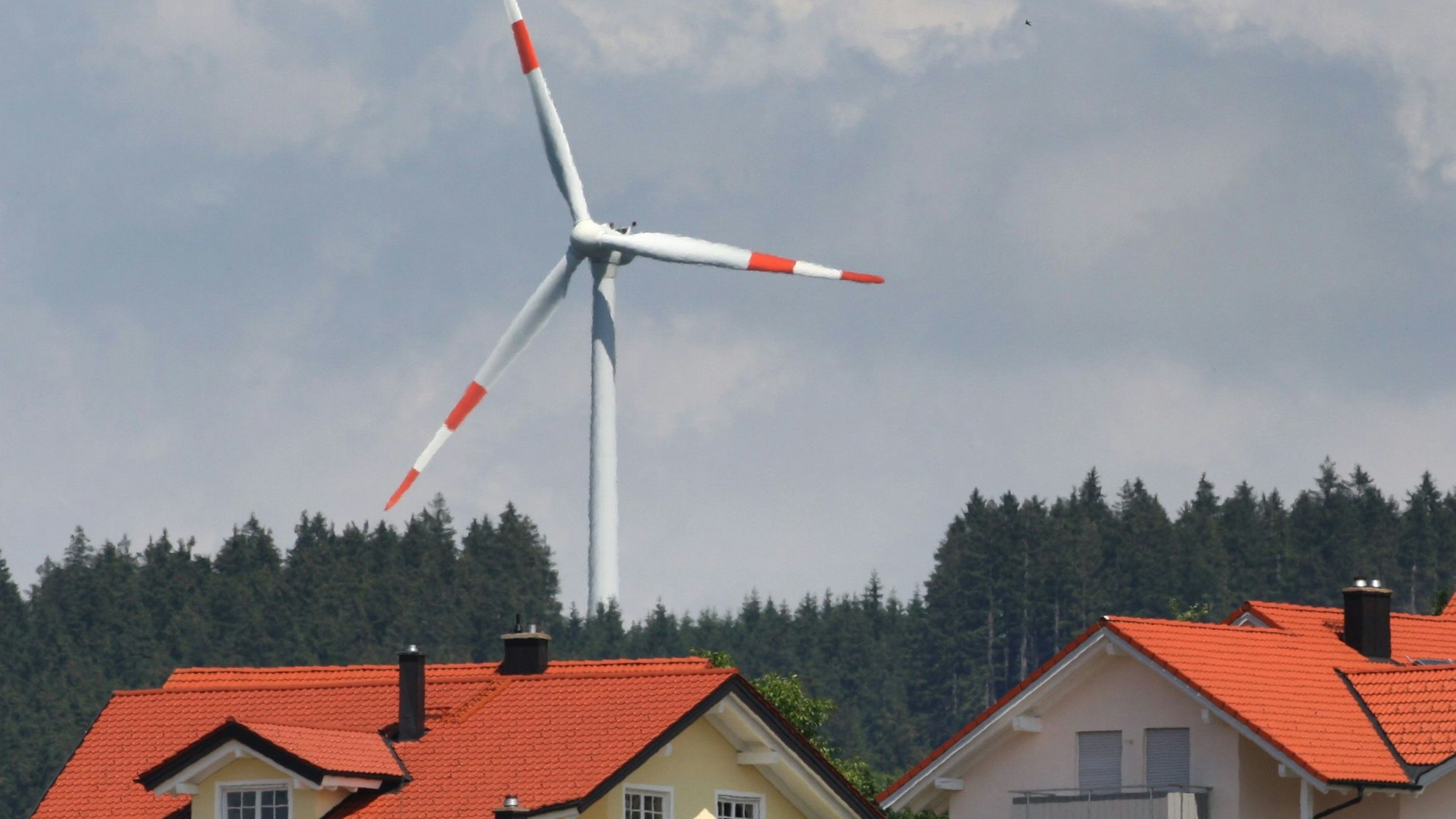Ein Windrad steht am 21.06.2012 hinter einer Neubausiedlung in Wildpoldsried (Bayern).