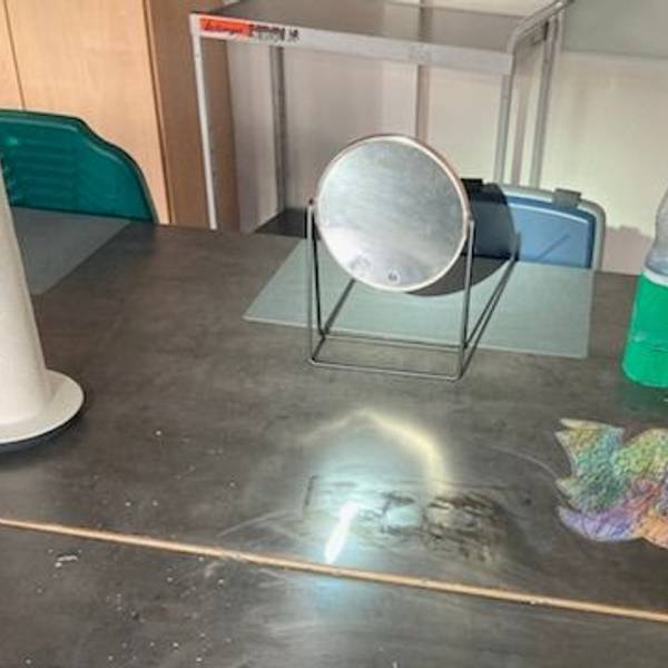 Ein Spiegel steht auf einem Arbeitstisch.