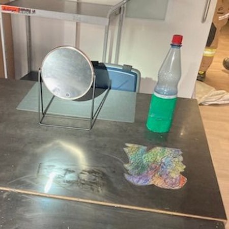 Ein Spiegel steht auf einem Arbeitstisch.