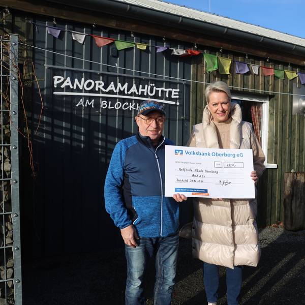 Bernhard Junge übergibt vor der Panoramahütte am Blockhaus eine Spende an Bettina Hühn.