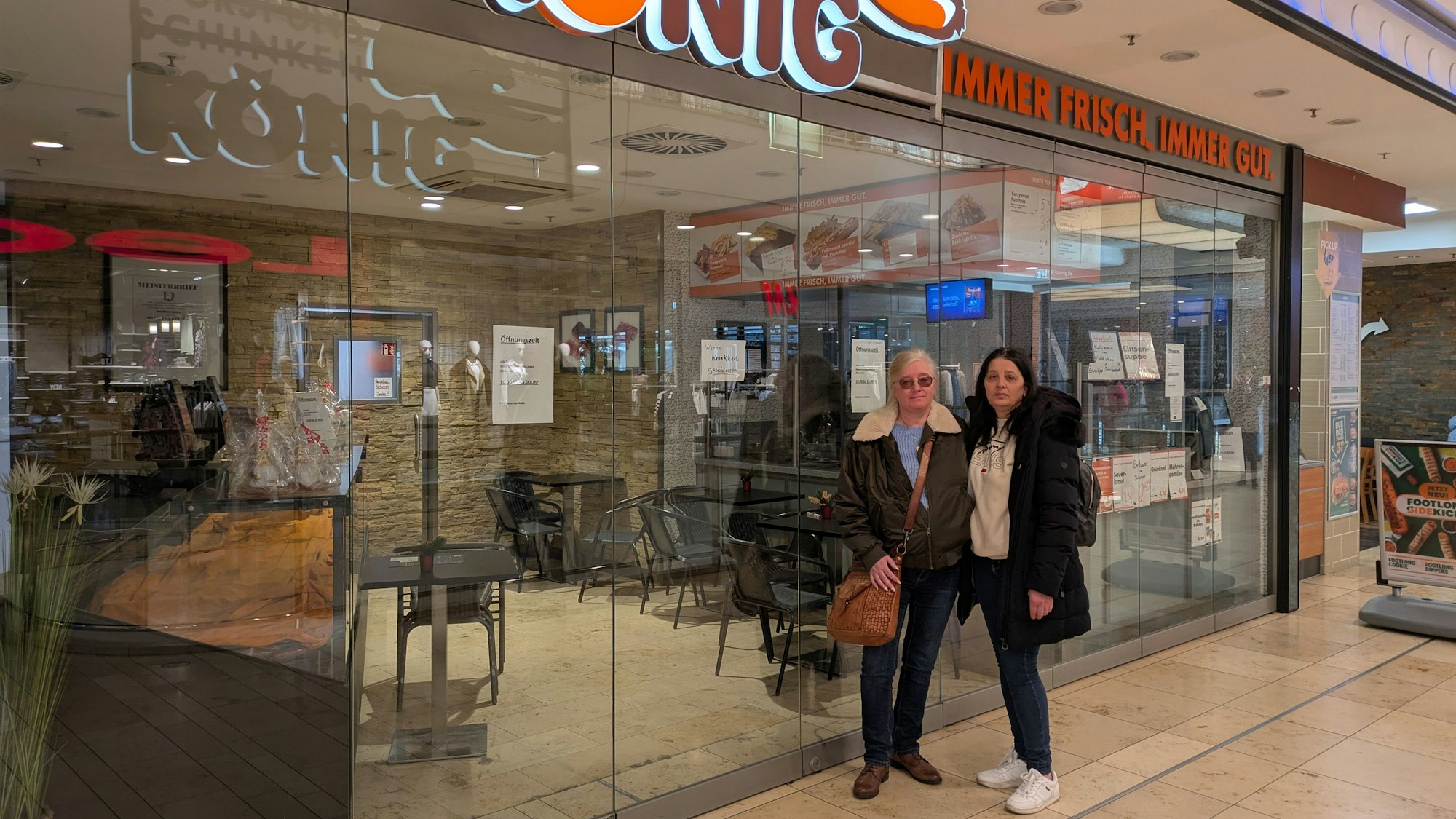 Zwei Frauen stehen vor einer geschlossenen Metzgerei-Filiale.