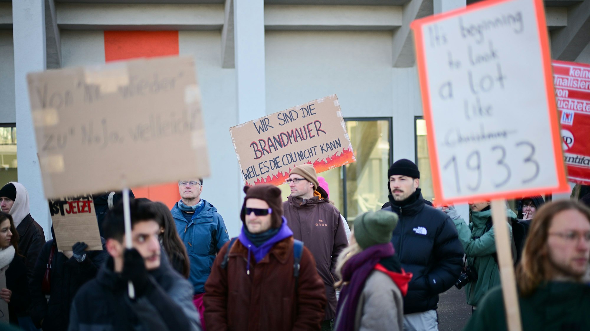 Demonstranten mit Schildern stehen vor Beginn des 37. Bundesparteitag der CDU im CityCube Berlin vor dem Veranstaltungsgelände.