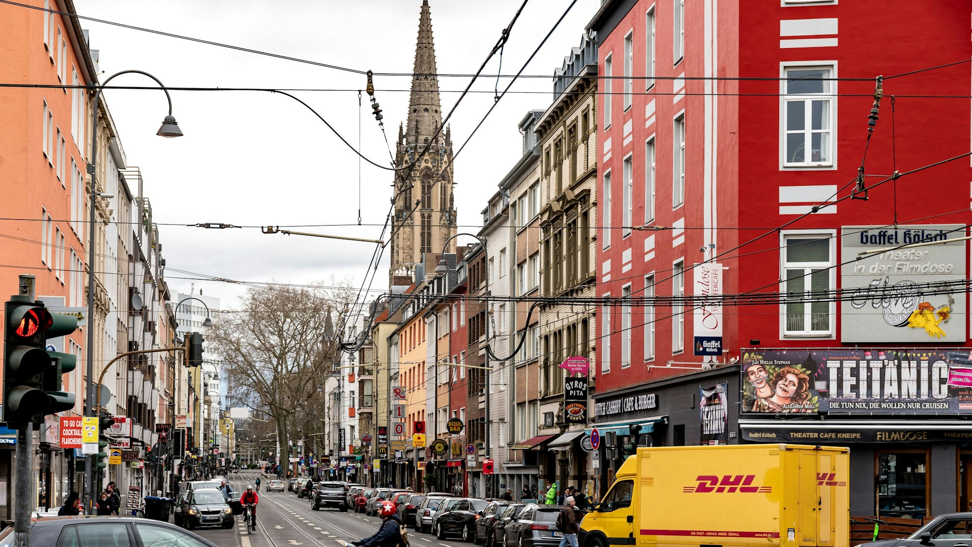 Blick in die Zülpicher Straße in Köln. Neben Autos ist im Hintergrund ein Kirchturm zu sehen.