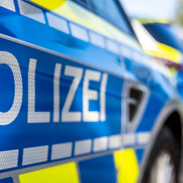 An der Tür von einem Streifenwagen steht der Schriftzug „Polizei“