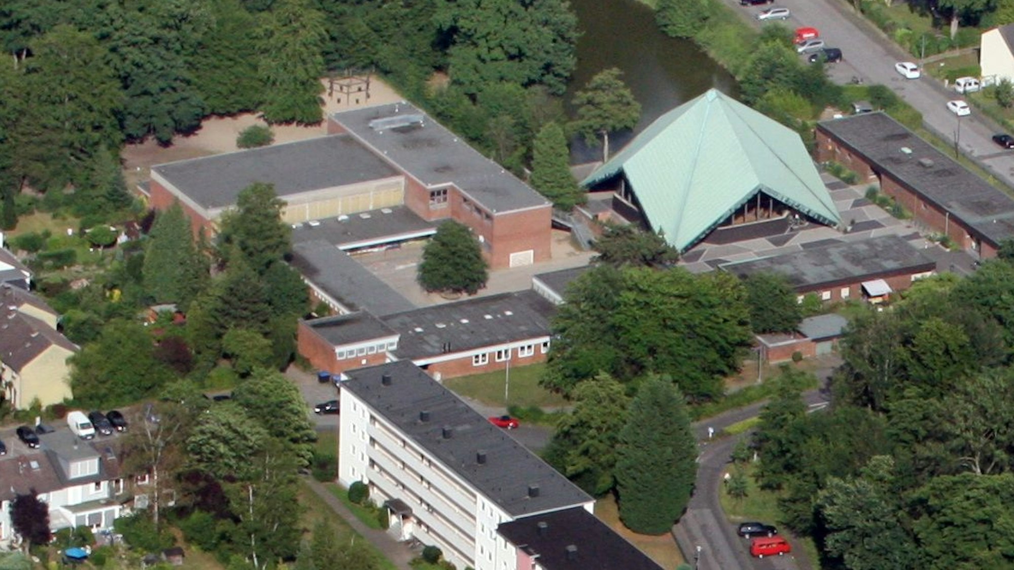 Auf einem Luftbild sind Häuser, die Zeltkirche und die Grundschule von Bergisch Gladbach-Kippekausen zu sehen.
