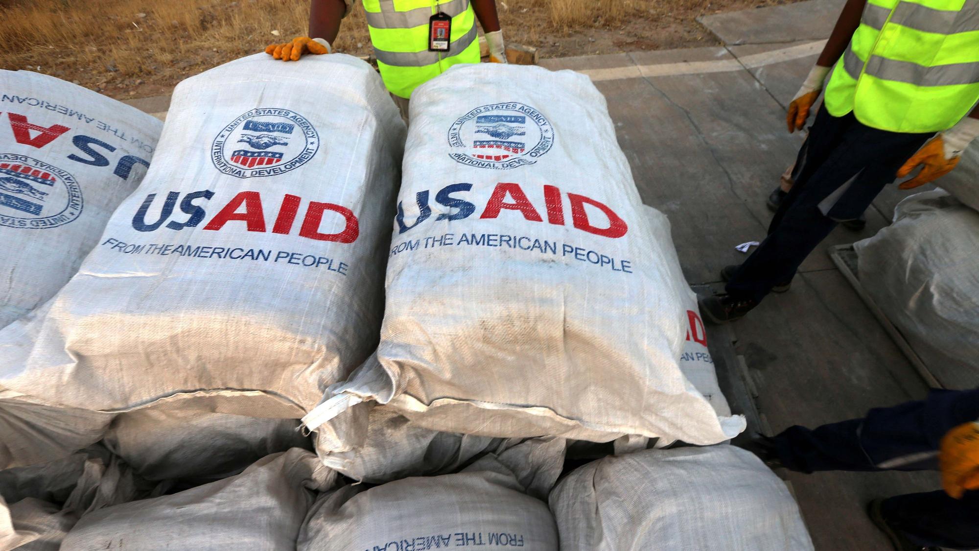 Flughafenpersonal steht 2014 im Irak vor 60 Tonnen Hilfsgütern, die die Entwicklungsbehörde USAID zur Verfügung gestellt hatte. Nun ist die Zukunft der Behörde unter Trumps zweiter Amtszeit ungewiss. (Archivbild)