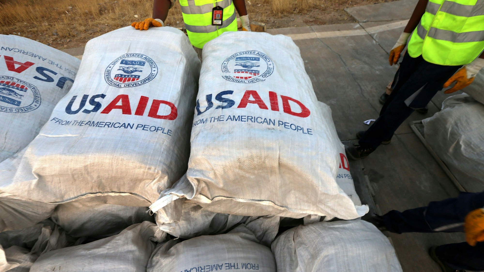 Flughafenpersonal steht 2014 im Irak vor 60 Tonnen Hilfsgütern, die die Entwicklungsbehörde USAID zur Verfügung gestellt hatte. Nun ist die Zukunft der Behörde unter Trumps zweiter Amtszeit ungewiss. (Archivbild)