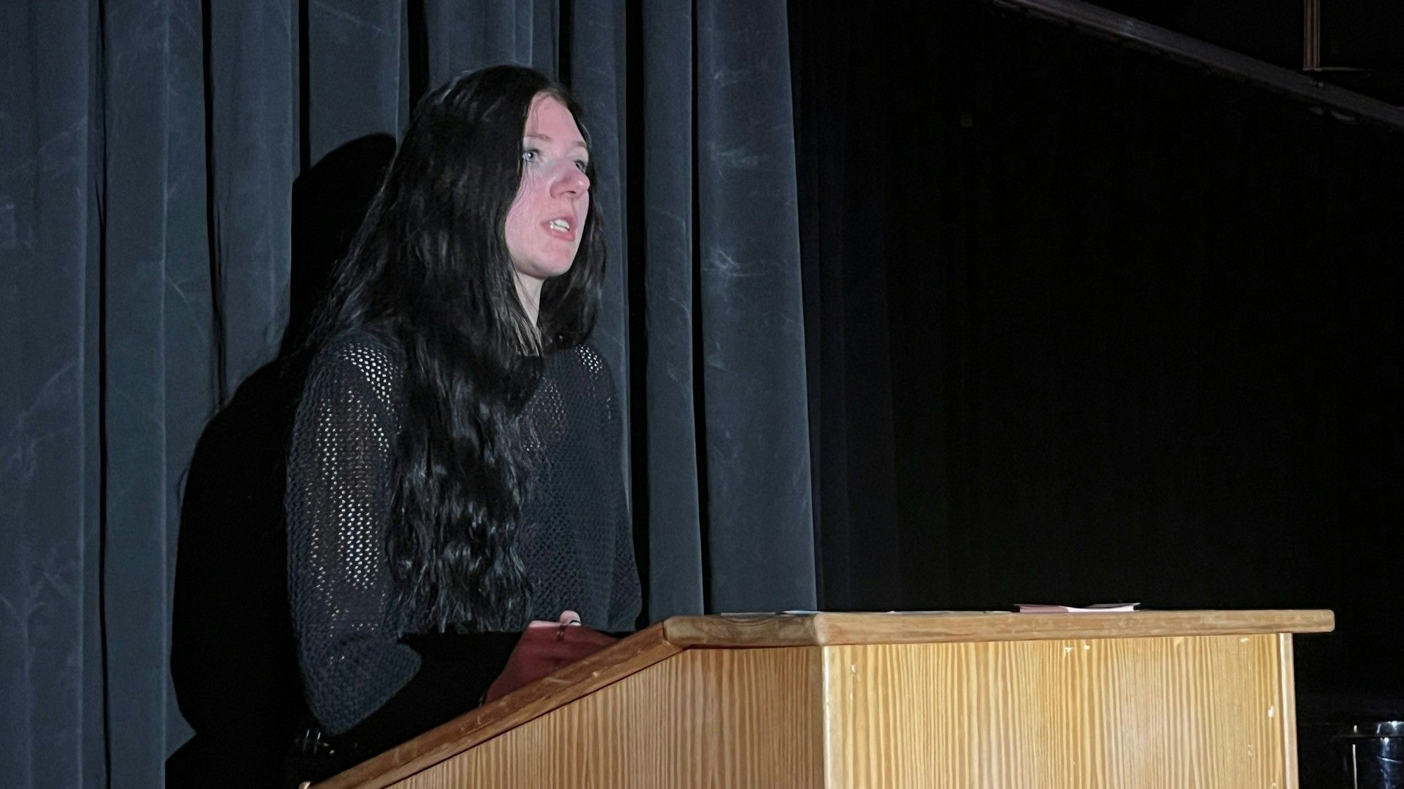 Eine junge Frau steht an einem Rednerpult.