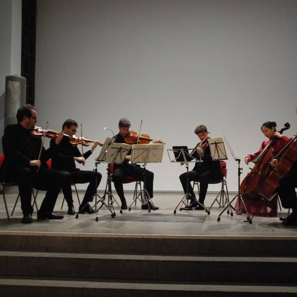 Auf der Bühne sitzen im Halbkreis sechs Streicher und musizieren.