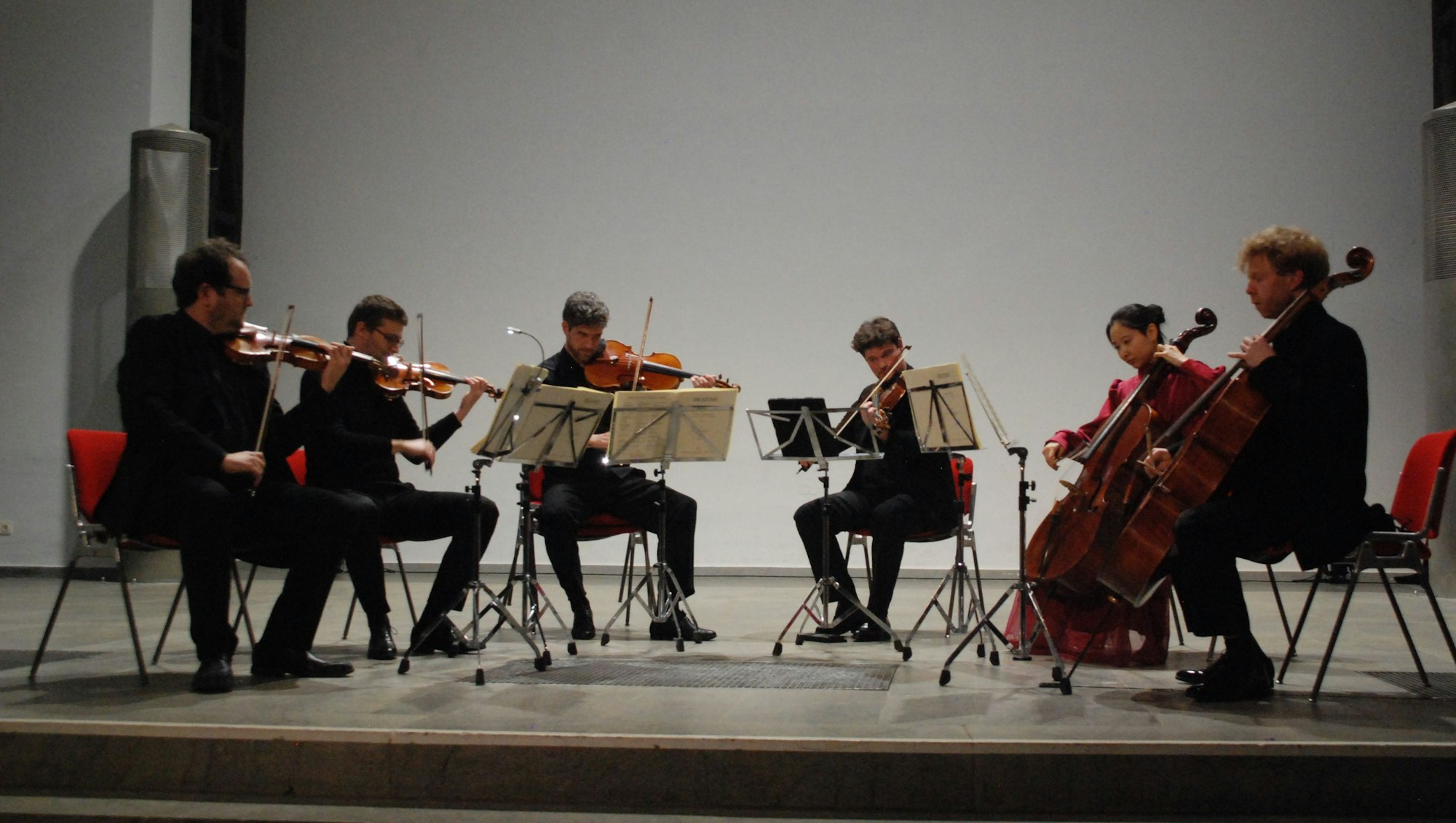 Auf der Bühne sitzen im Halbkreis sechs Streicher und musizieren.