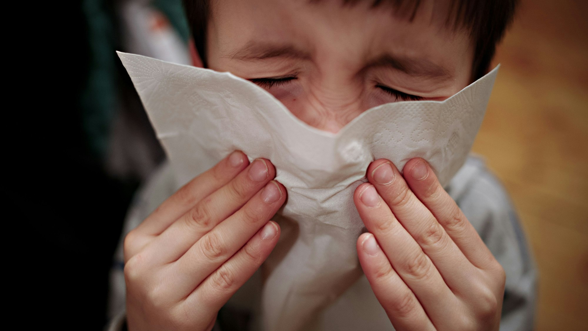 ARCHIV - 23.01.2014, NA, Berlin: ARCHIV - ILLUSTRATION - Ein kleiner Junge hält sich am 24.01.2014 in Berlin ein Taschentuch an die Nase. Foto\ Nicolas Armer/dpa +++(c) dpa - Bildfunk+++ (zu dpa: «Deutlich mehr Grippefälle insbesondere bei Kindern») Foto: Nicolas Armer/dpa +++ dpa-Bildfunk +++