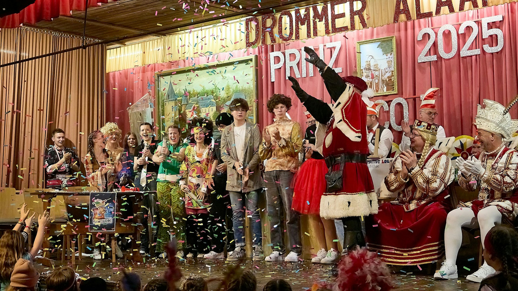 Mehrere Karnevalisten stehen auf der Bühne in Schleiden-Dreiborn. Es regnet bunte Konfetti-Schnipsel.