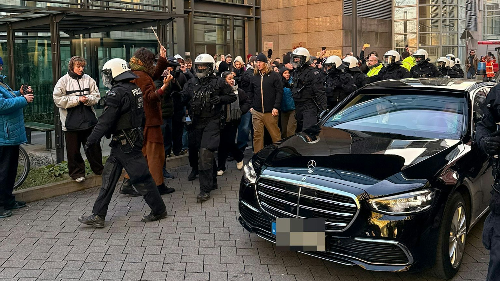 Demonstrierende blockieren in Köln den Wagen von Friedrich Merz.
