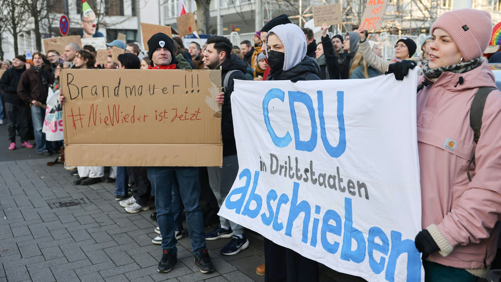 Demonstranten protestieren gegen Unionskanzlerkandidat Friedrich Merz an der Uniklinik in Köln.