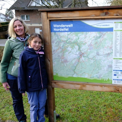 Christina und Thomas Mießeler aus Nettersheim (hier mit Tochter Lina) posieren an einer Wandertafel am Naturzentrum in Nettersheim.