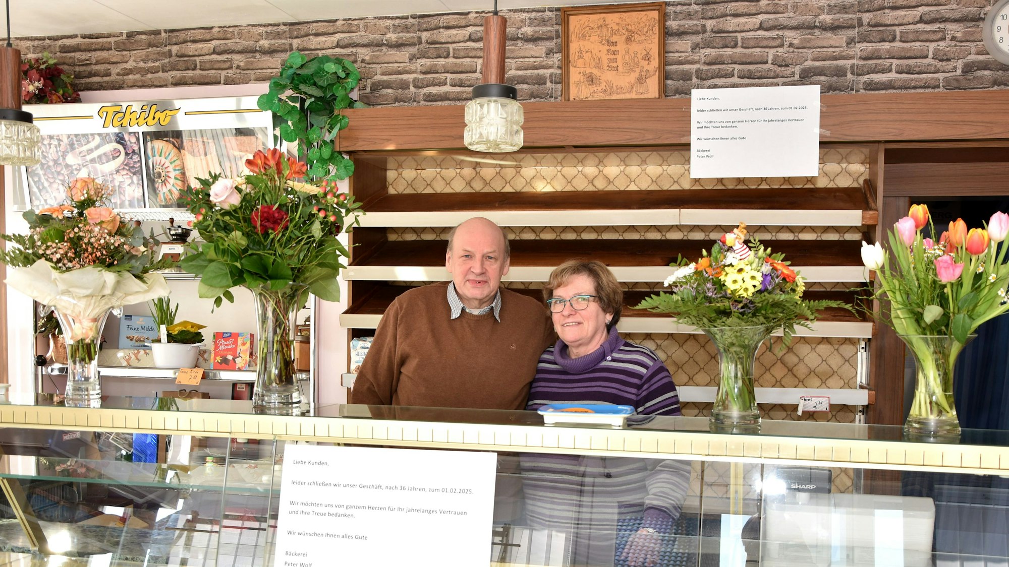 Das Bild zeigt das Ehepaar Wolf hinter der Theke ihrer Bäckerei.