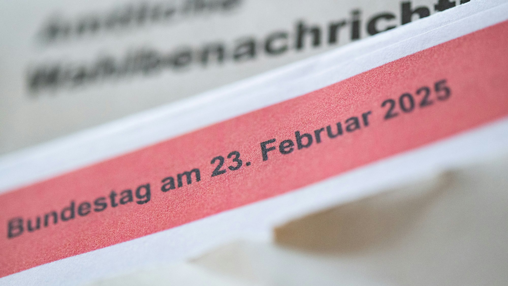 Eine geöffnete amtliche Wahlbenachrichtigung zur Wahl zum deutschen Bundestag am 23. Februar 2025 liegt auf einem Tisch.