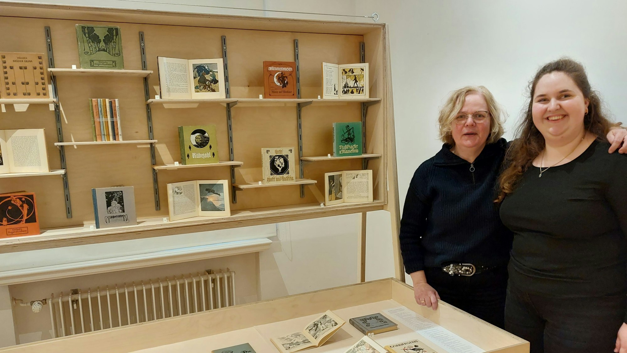Zwei Frauen stehen neben Ausstellungsvitrinen in einem Museum.