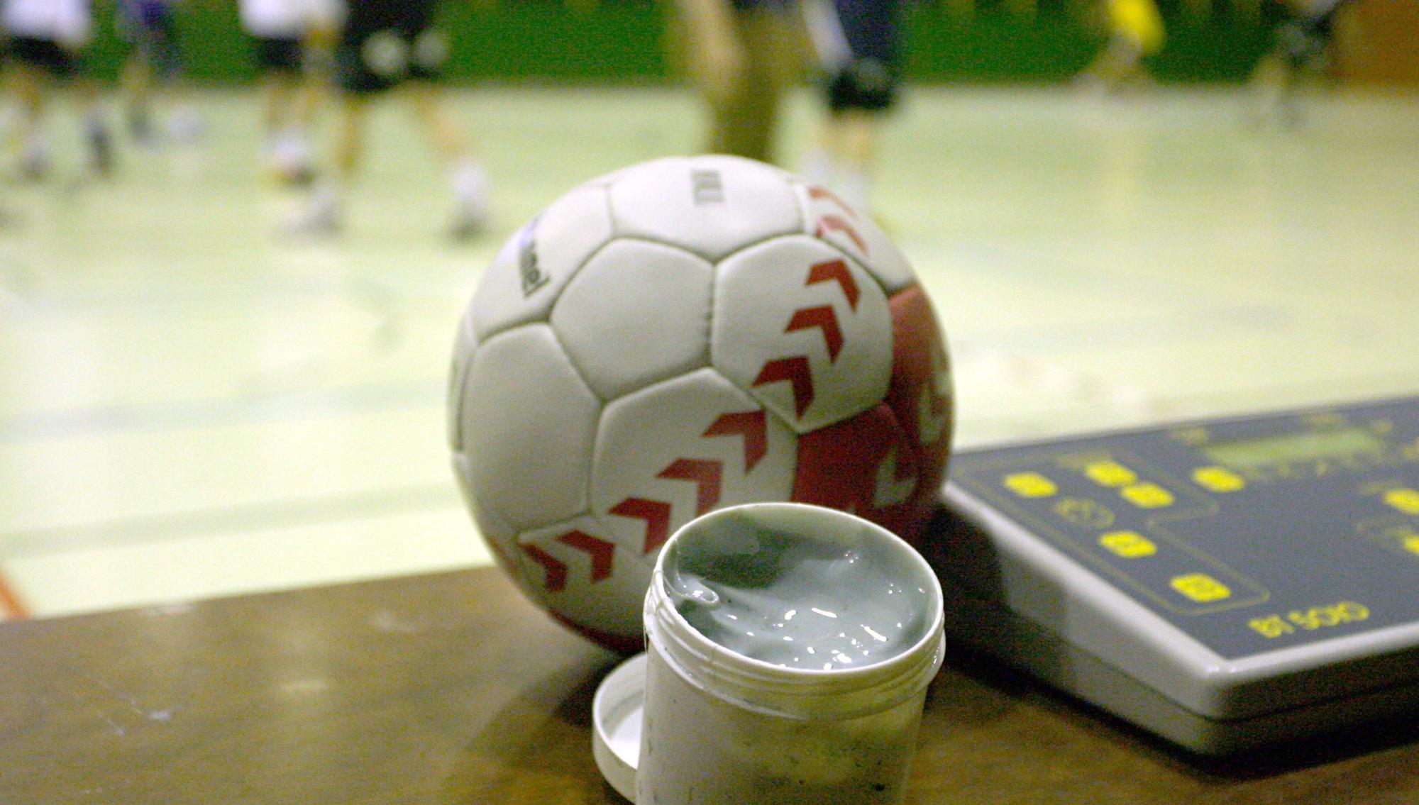 Zu sehen ist ein Handball und eine Dose mit Harz.
