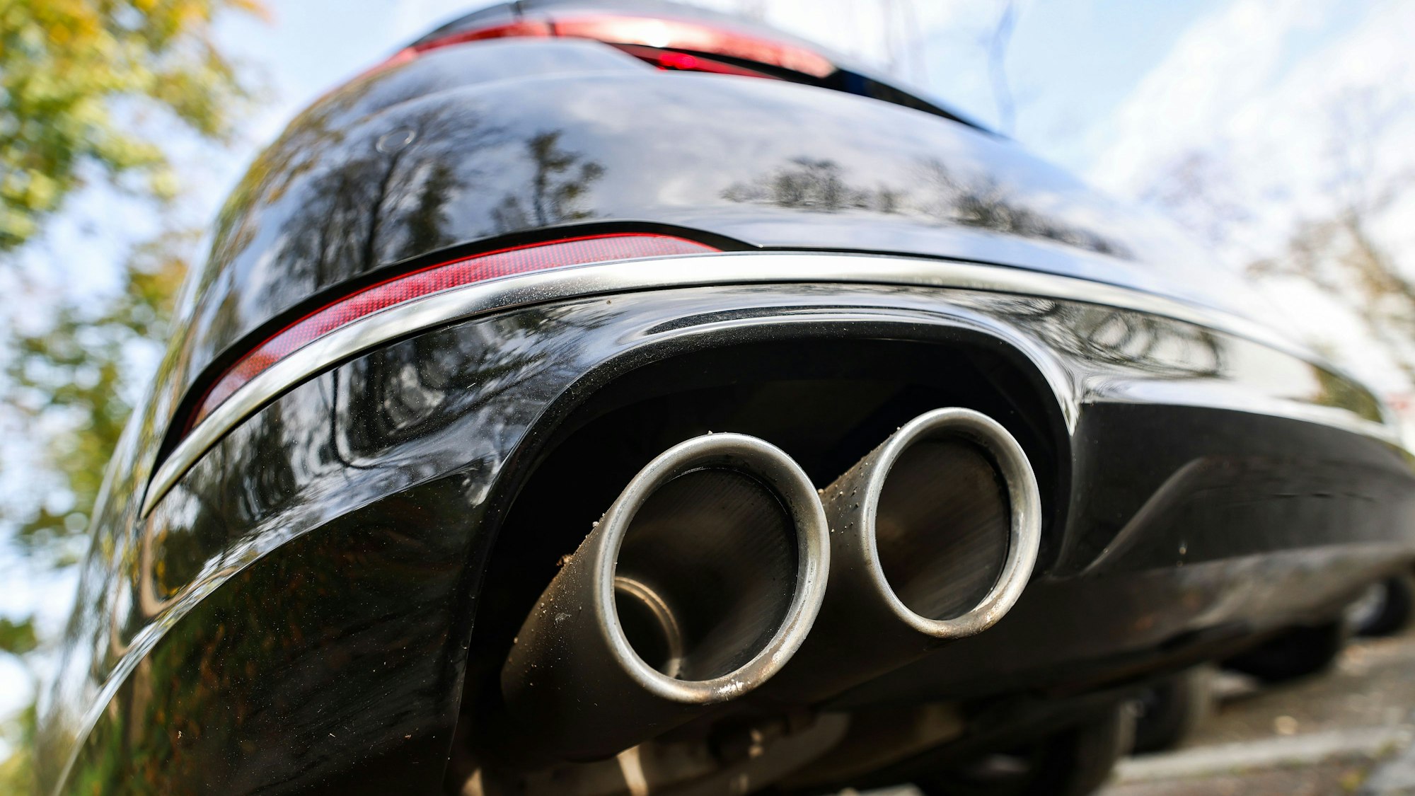 ARCHIV - 28.10.2022, Nordrhein-Westfalen, Bonn: Ein Pkw mit doppeltem Auspuff steht auf einem Parkplatz. (zu dpa: «Behörden vermuten Russland hinter Auto-Sabotageserie») Foto: Oliver Berg/dpa +++ dpa-Bildfunk +++