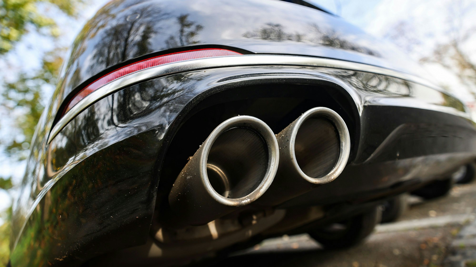 ARCHIV - 28.10.2022, Nordrhein-Westfalen, Bonn: Ein Pkw mit doppeltem Auspuff steht auf einem Parkplatz. (zu dpa: «Behörden vermuten Russland hinter Auto-Sabotageserie») Foto: Oliver Berg/dpa +++ dpa-Bildfunk +++