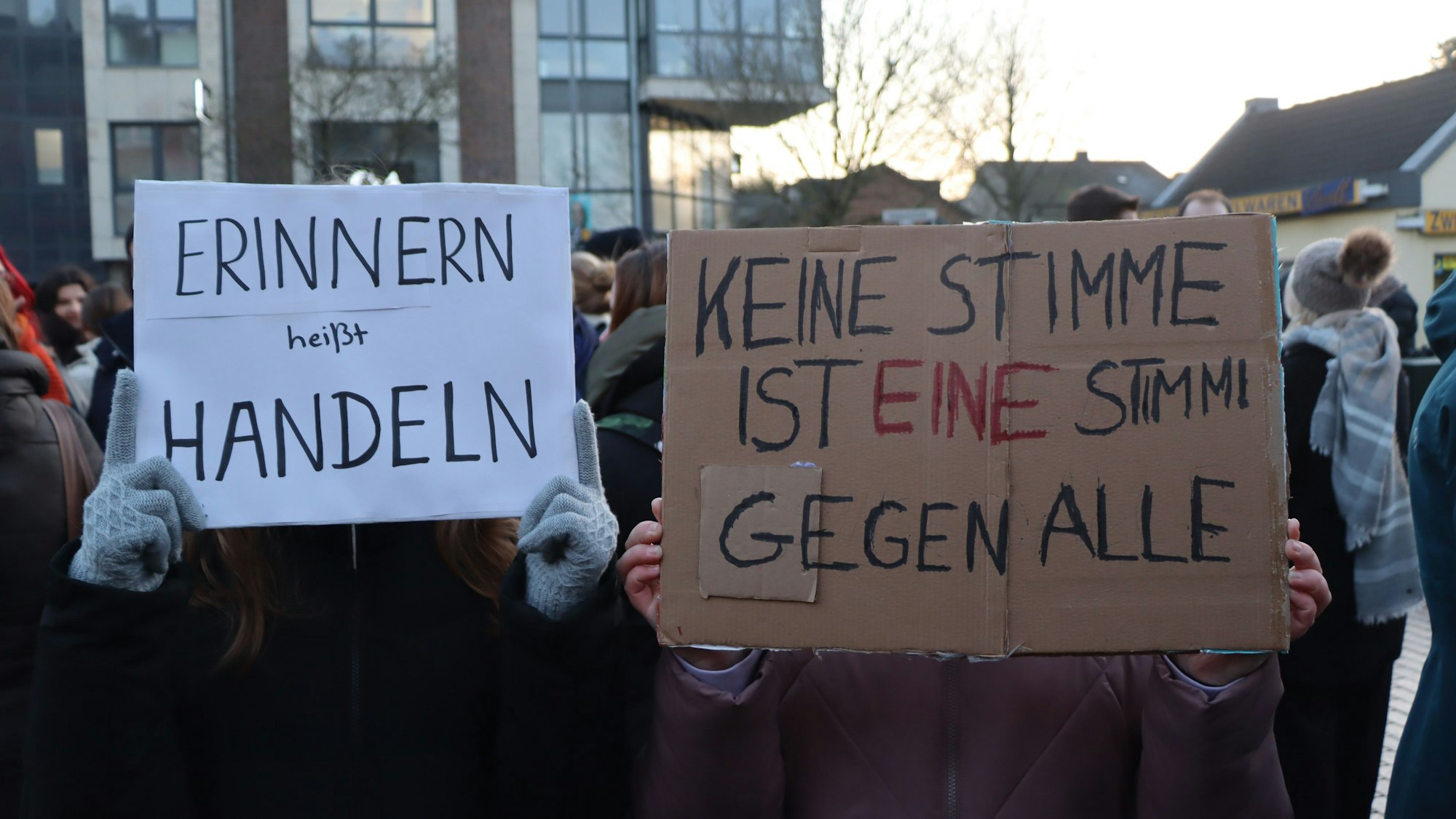 Teilnehmende der Demo halten selbst gestaltete Plakate hoch.