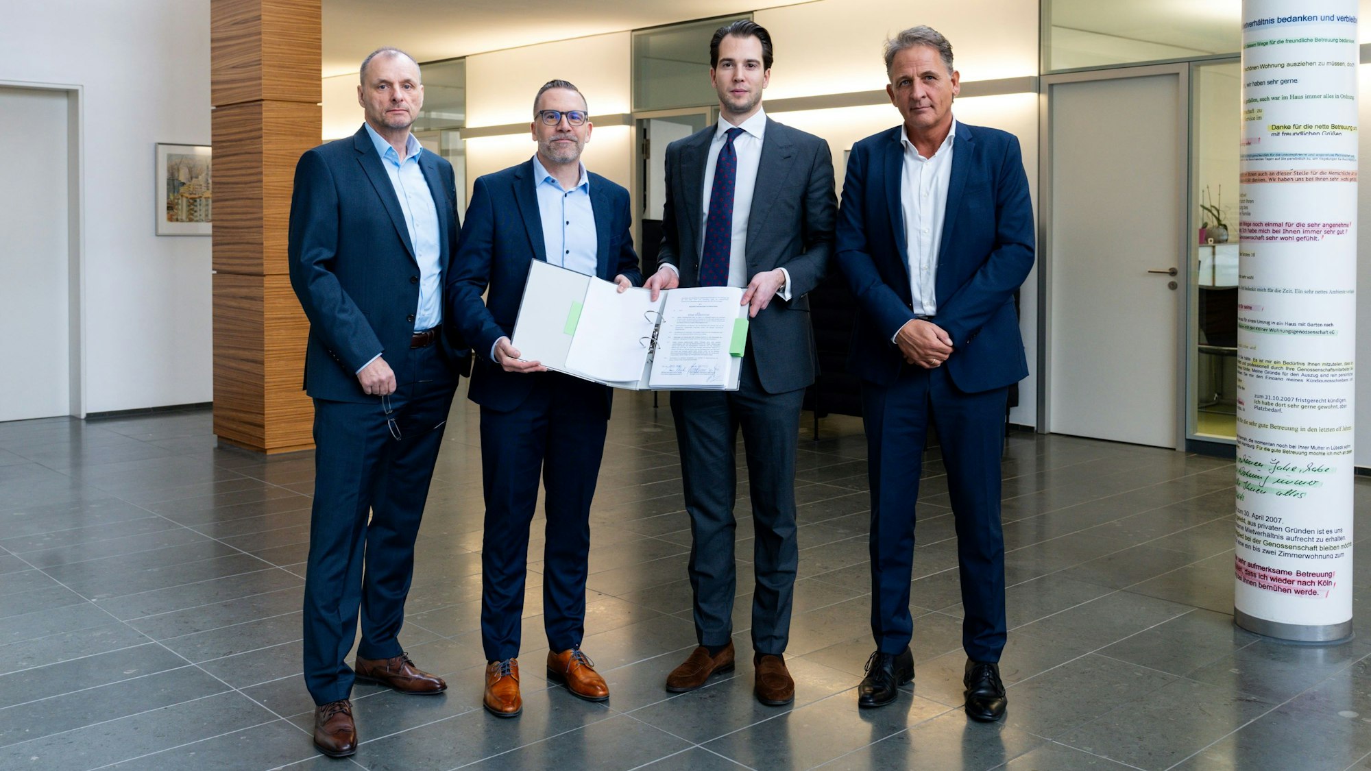 Peter Schade und Christoph Moossen (Kölner Wohnungsgenossenschaft) sowie Fabian Bauwens-Adenauer und Joerg Giesen (Bauwens) präsentieren den Vertrag.