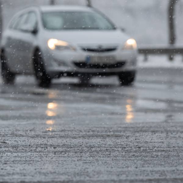 Schneematsch liegt vor einem Auto auf der Straße. (Symbolfoto)