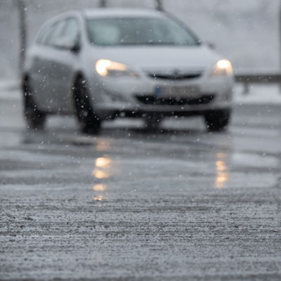 Schneematsch liegt vor einem Auto auf der Straße. (Symbolfoto)