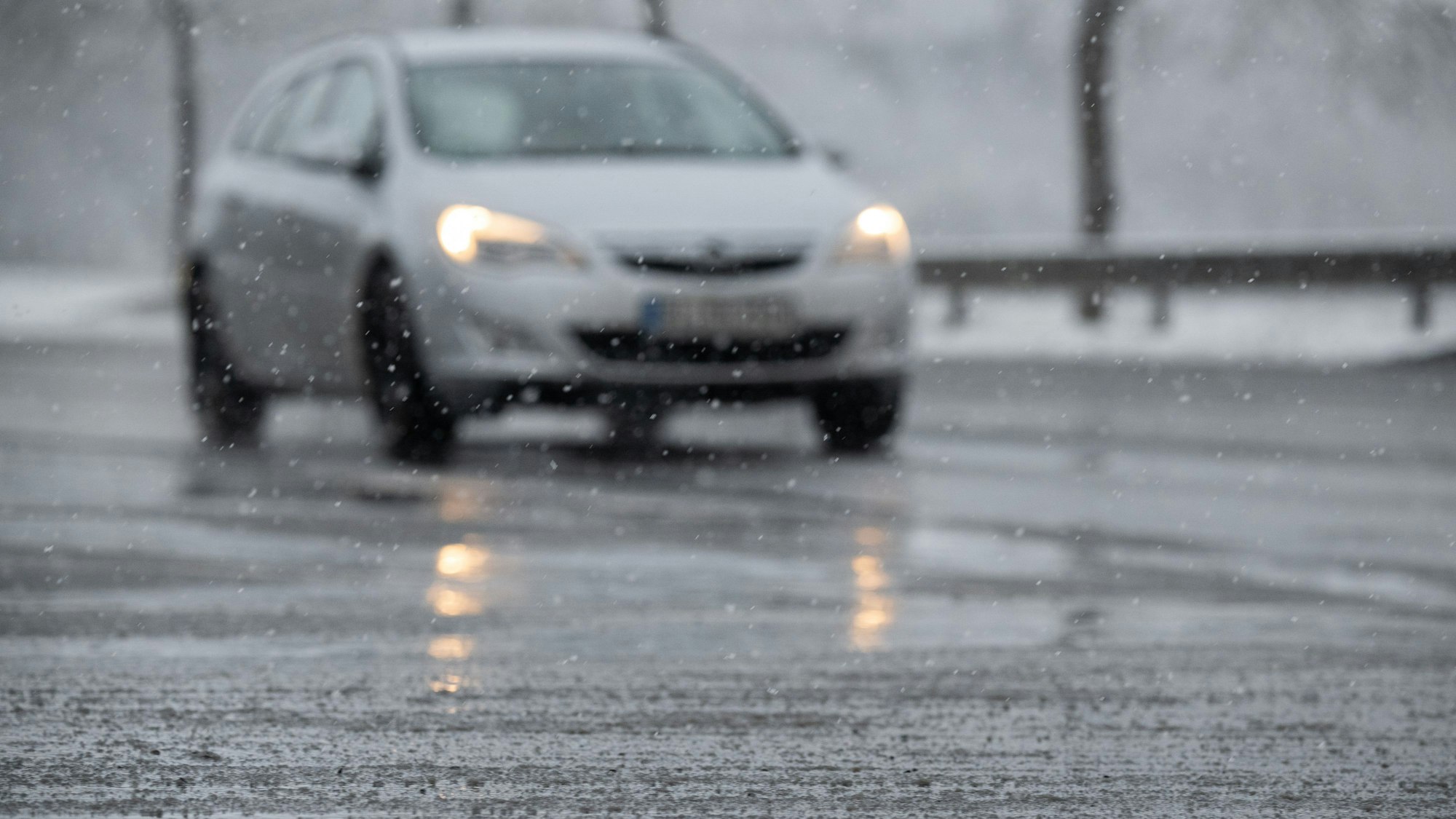 Schneematsch liegt vor einem Auto auf der Straße. (Symbolfoto)