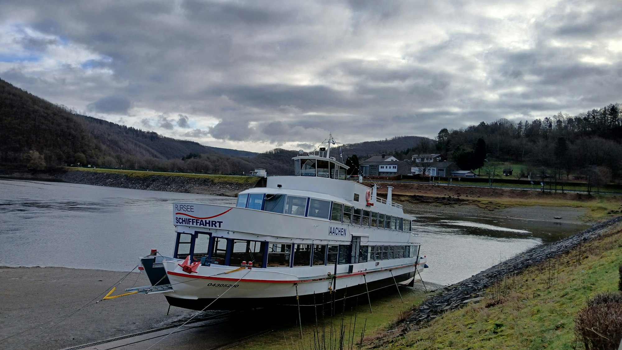 Das Fahrgastschiff Aachen liegt in Rurberg neben dem Wasser des Rursees auf dem Trockendock, damit daran gearbeitet werden kann.