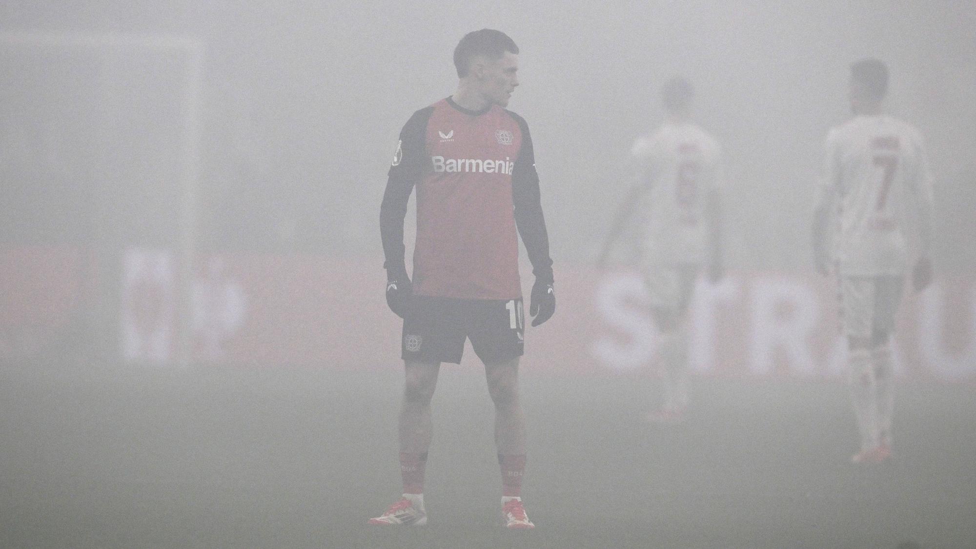 Florian Wirtz steht in der Bay-Arena im Rauch von Pyrotechnik auf dem Platz.