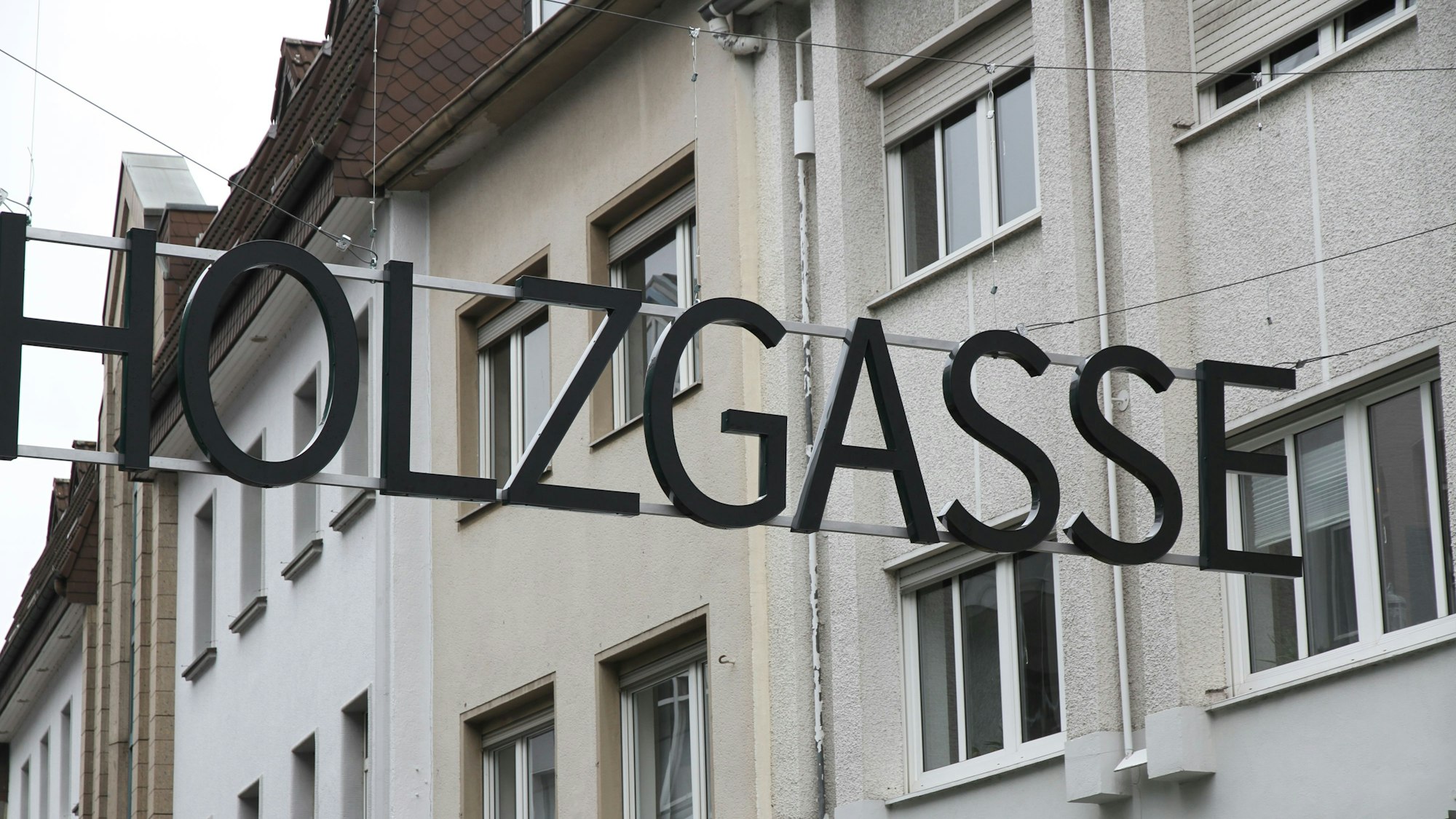 Ein Schriftzug aus metallenen Großbuchstaben über einer Einkaufsstraße.